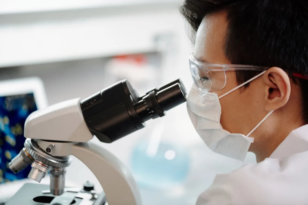 Researcher examining a sample under a microscope in a laboratory
